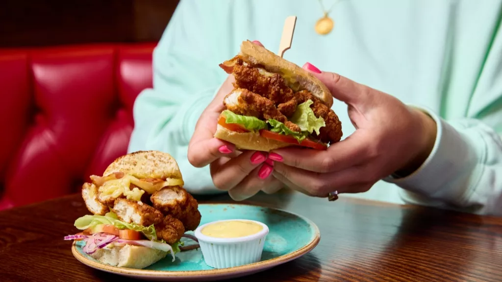 woman holding lunch chicken finger BLT