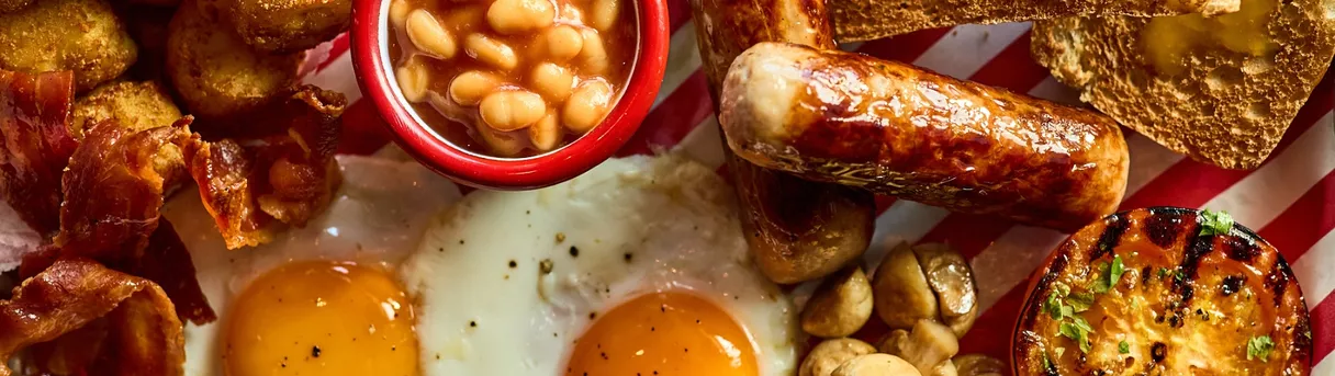 eggs, sausages, beans and mushrooms ion a breakfast plate