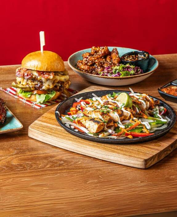 burger, fajitas and wings selection of food on a table