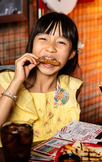 kid at table enjoying meal